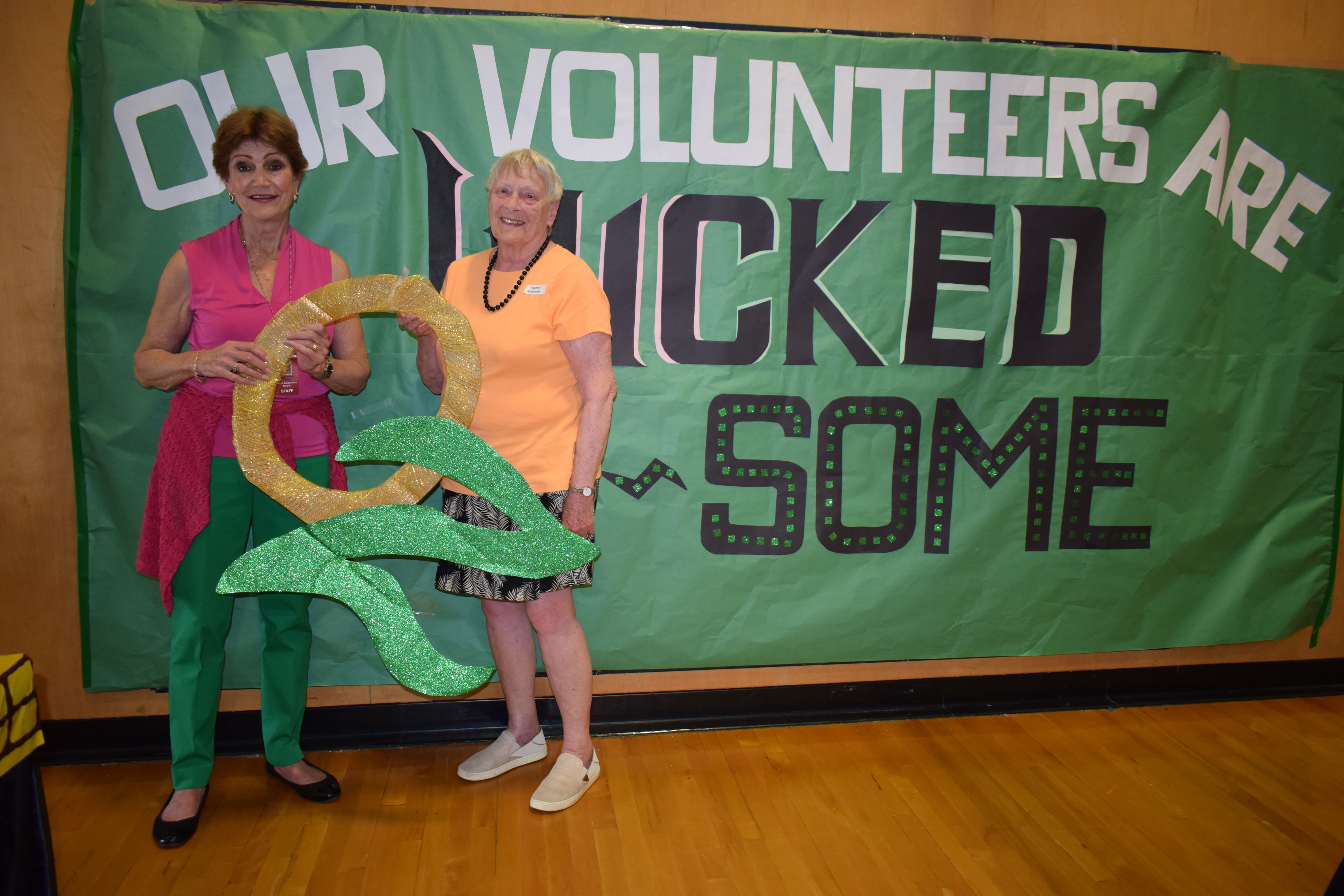 In the photo are Maryanne Foley (left) and Volunteer of the Year Marilyn Wade. Both are holding the letters OZ with the banner reading, “Our volunteers are Wicked OZsome.”